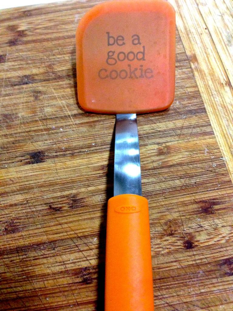 orange oxo "be a good cookie" spatula sitting on a cutting board